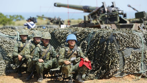 Taiwan's military rest behind self-propelled Howitzers during the annual Han Kuang exercises in Hsinchu.
