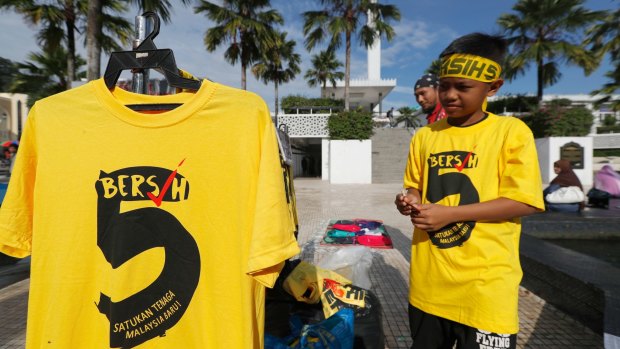 Protesters sell "Bersih" T-shirts outside a national mosque during the rally in Kuala Lumpur, on Saturday.