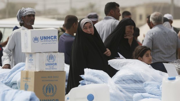 Iraqis internally displaced wait for humanitarian aid being distributed at a refugee camp in Baghdad's western neighborhood of Ghazaliyah, Iraq, last week.