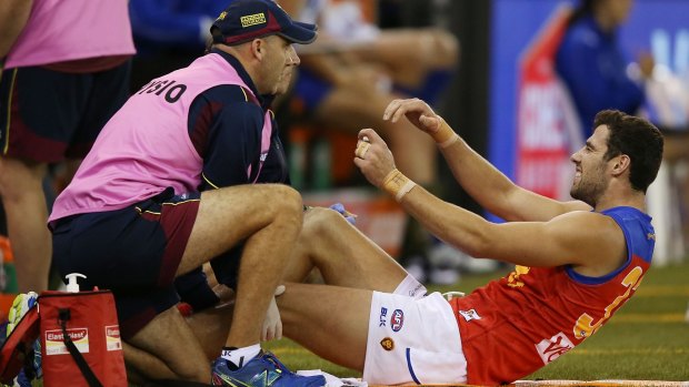 Michael Close of the Brisbane Lions reacts in pain after a knee injury during a round two match against North Melbourne on April 12.