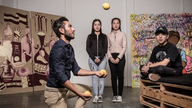 Young migrants (from left) Mario Kharat, twins Mengjun and Mengchen, with Van Hien Ta, alongside their artworks.