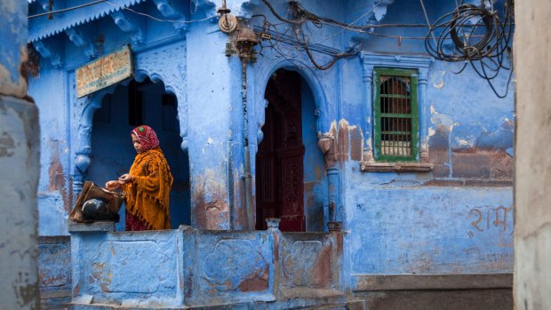 Indian woman standing on her terrace in Jodhpur, India's Blue city.