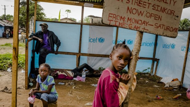People with Ebola symptoms, or who have family members showing such symptoms, wait to be admitted at the JFK Ebola treatment center in Monrovia, Liberia last year. 