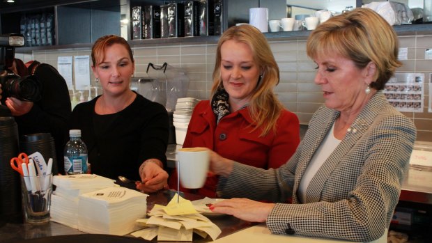 Coffee Club employee Patsy Polchleb, of Jamisontown, helps Foreign Minister Julie Bishop make a cappuccino at Nepean Village shopping centre, Penrith, while Lindsay MP Fiona Scott looks on.