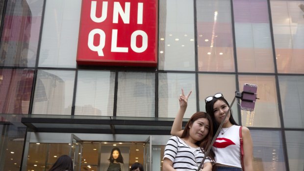 Women take a selfie outside the Uniqlo store in Beijing where a steamy video purportedly taken inside one of its fitting room showing a couple apparently having sex was filmed.