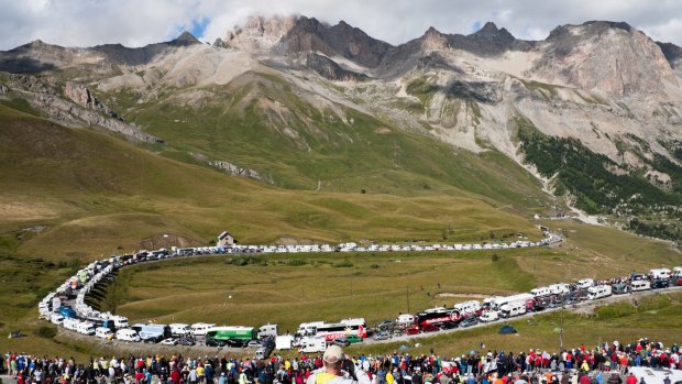 Spectators, cyclists, campervans and team buses line the roads at the bottom of the Col du Galibier.
