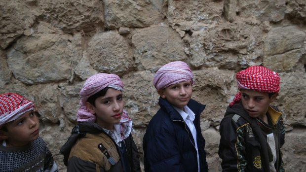 Yazidi boys wait to kiss the entrance of the Temple of Lalish, the holiest site of the Yazidi religion, last week in the Nineveh Province village of Lalish, Iraq. 