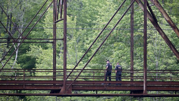 Law enforcement officers keep lookout from a bridge spanning the Saranac River as the search for prison escapees David Sweat and Richard Matt continues.