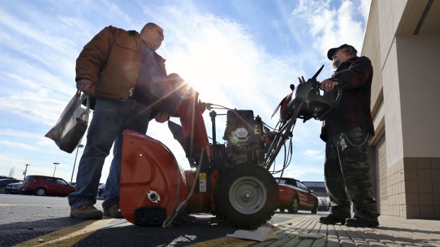 Pennsylvania residents discuss the pros and cons of various snowblowers outside a Lowe's home improvement warehouse in Langhorne, 
