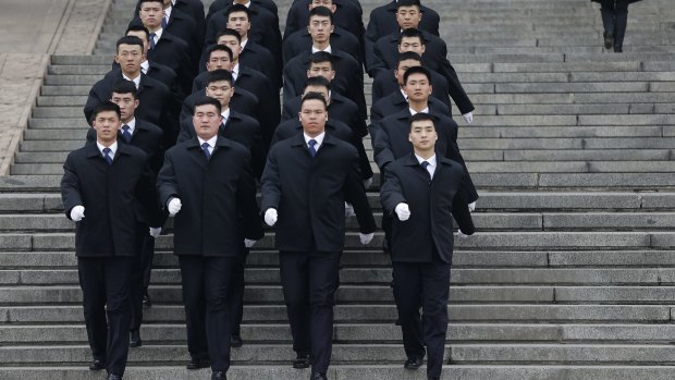Soldiers dressed as ushers march out of the Great Hall of the People during on Thursday.