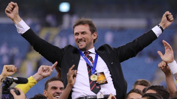 Western Sydney Wanderers players hold up their coach, Tony Popovic, as they celebrate their historic Asian Champions League victory in Riyadh.