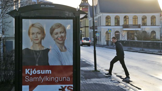 A man walks near a social democrats election poster in Reykjavik.