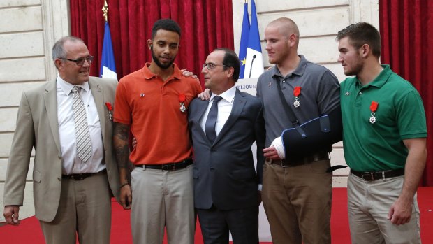 French President Francois Hollande (centre) poses with (from left) British businessman Chris Norman,  Anthony Sadler, Spencer Stone and Alek Skarlatos.
