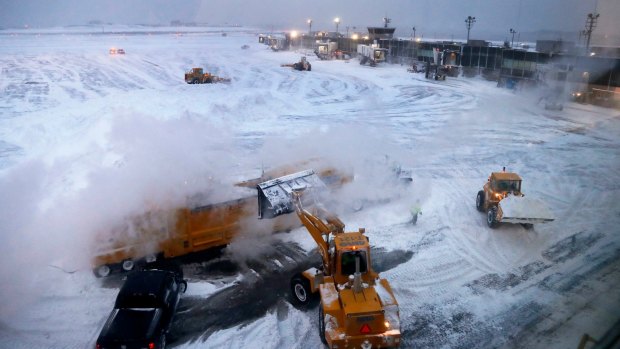 Front loaders dump snow into a melter while clearing the apron around Terminal B at LaGuardia Airport, New York.