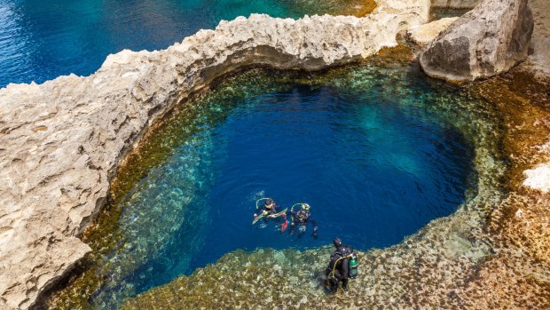 Underwater cave in the form of heart and divers at Azure Window in Gozo, Malta.