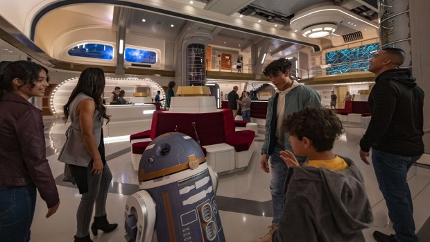 Astromech droid SK-62O greets guests in the Atrium of the Halcyon starcruiser.
