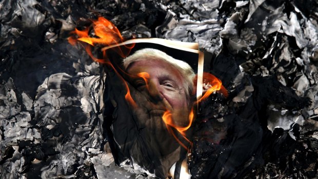 A portrait of US President Donald Trump is set on fire by Iranian mourners on Wednesday at the state funeral of Mohsen Hojaji, a young Revolutionary Guard soldier beheaded by the Islamic State in Syria.