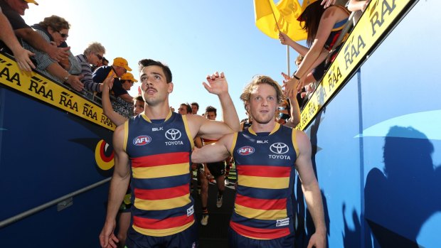 Adelaide captain Taylor Walker and teammate Rory Sloane return to the rooms after their team's big win over West Coast.