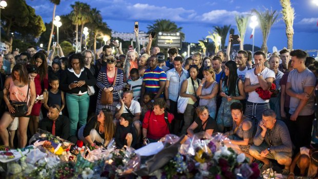 People gather at a makeshift memorial to honour the victims of the Bastille Day attack in Nice on Friday.