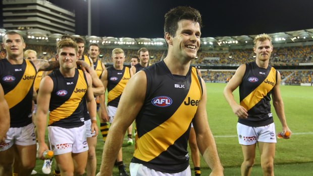 A smiling Trent Cotchin leads his team off the field after a resounding win.