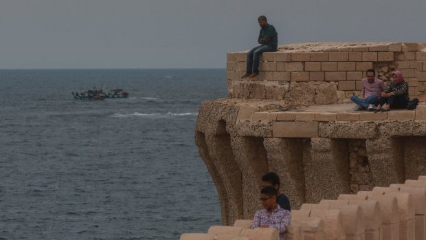 People look out over the Mediterranean Sea from the coastline of Alexandria where about 290 kilometers north, search operations are taking place to locate the wreckage of EgyptAir flight MS840.