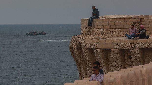 People look out over the Mediterranean Sea from the coastline of Alexandria where about 290 kilometers north, search operations are taking place to locate the wreckage of EgyptAir flight MS840.