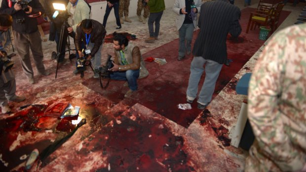 Pakistan media take footage of the bloodied floor at an army-run school a day after an attack by Taliban militants in Peshawar.