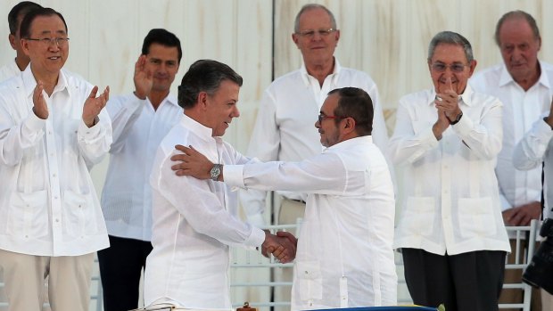 Colombian President Juan Manuel Santos, front left, and the top FARC Timochenko, shake hands after signing the peace agreement. Behind, from left, are UN's Ban Ki-moon, Mexican President Enrique Pena Nieto, Peruvian President Pedro Pablo Kuczynski, Cuban President Raul Castro, and Spain's former King Juan Carlos.