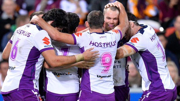 Too strong: Cheyse Blair of the Storm is congratulated by teammates after scoring his first try at Suncorp Stadium.