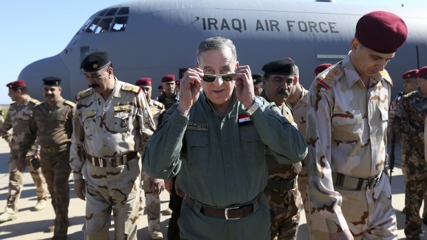 Iraqi Defence Minister Khaled al-Obeidi, centre, arrives at a military base outside Tikrit, north of Baghdad, on Wednesday where he played down fears of Islamic State's chemical weapons capabilities.
