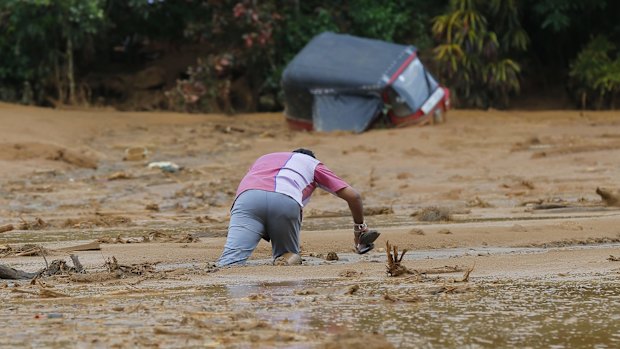 An man stuck in the mud after a landslide in Elangipitiya village.