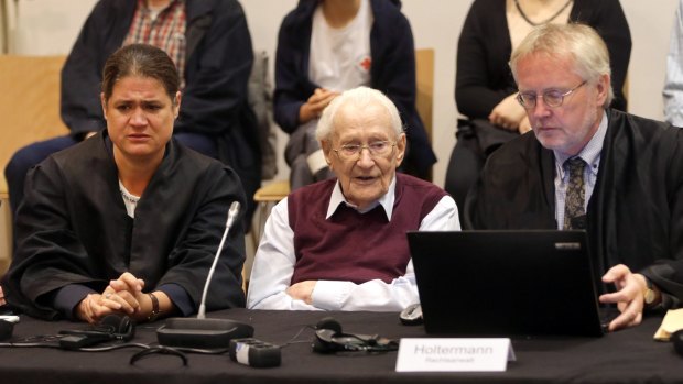 94-year-old former SS sergeant Oskar Groening sits between his lawyers Hans Holtermann, right, and Susanne Frangenberg, left, during the verdict of his trial.