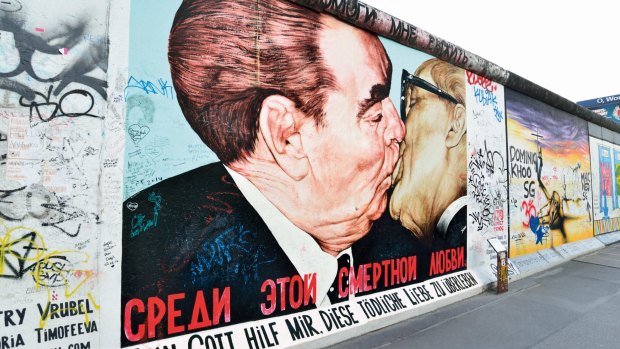 Soviet leader Leonid Brezhnev kisses East German leader Erich Honecker on the East Side Gallery section of the Berlin Wall.