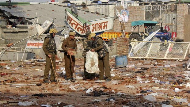 Cleaning up: Policemen collect belongings left behind after people left the ashram.