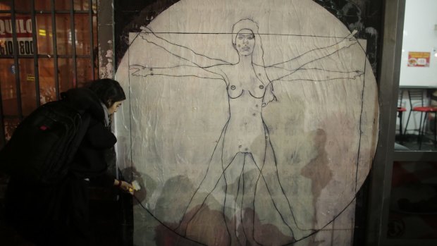 Artist Cecilia Coppo makes a mural that resembles Leonardo da Vinci's Vitruvian Man but using a woman as a model during a march against domestic violence in Buenos Aires.