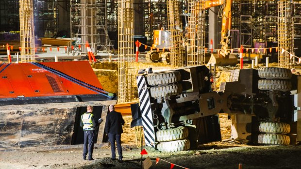 ACT Police, health and WorkSafe staff on the university construction site after a crane toppled killing a worker.