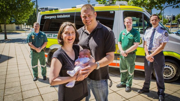 Calli and Chris Bowyer with 2-week-old Maisie, who was born on the side of Gunghalin Drive, reunite with their paramedic helpers.