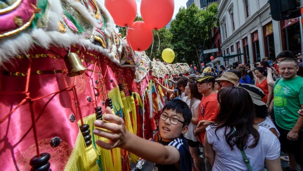 Chinese new year revellers reach out to touch Dai Loong (Big Dragon) for good luck as it makes its way along Russel Street.