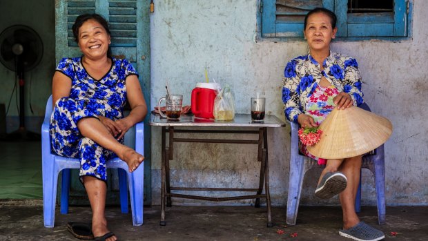 Vietnamese women drinking coffee along the Mekong River Delta, Vietnam.