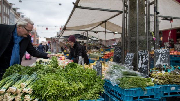 Customers check out fresh produce at the popular Albert Cuyp Market in Amsterdam.
