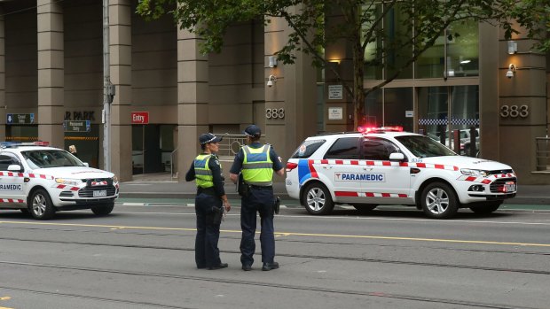 Police outside the AFP building on La Trobe Street on Monday evening.