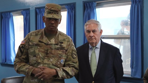 Rex Tillerson is briefed by US General Vincent Brooks while being photographed by a North Korean soldier at the village of Panmunjom.