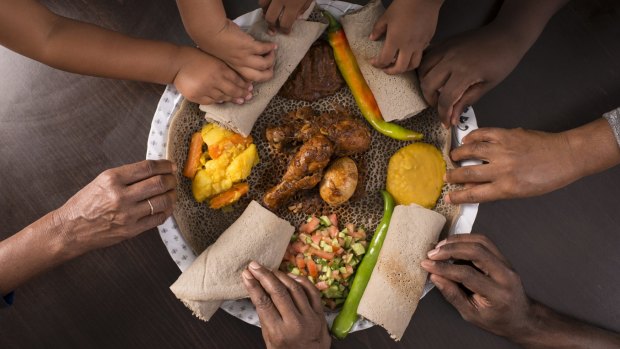 Injera is typically served communally, one large pancake with wots for a group of people who all eat with their hands.