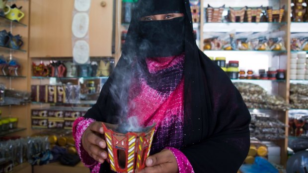 A veiled vendor at a frankincense shop at Al-Husn Souq in Salalah.