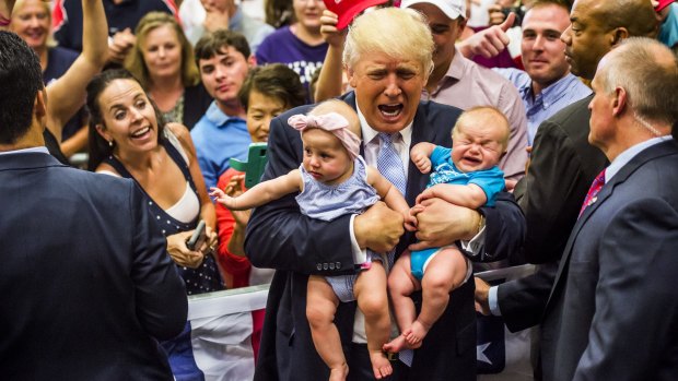 Republican presidential nominee Donald Trump holds baby cousins Evelyn Kate Keane, 6 months old, and Kellen Campbell, 3 months old, following his speech at the Gallogly Events Center at University of Colorado, Colorado Springs, on Friday. 