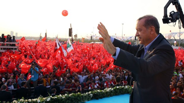 Turkey's President, Recep Tayyip Erdogan, salutes supporters as tens of thousands of flag-waving demonstrators rally to denounce violence by Kurdish rebels in Istanbul.