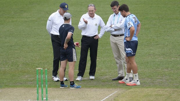 Players and officials inspect the pitch after rain prevented play on day one of the Sheffield Shield match between New South Wales and Victoria.