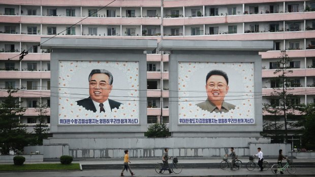 North Koreans are dwarfed by giant portraits of the late North Korean leaders Kim Il Sung and Kim Jong Il in Wonsan, North Korea. 