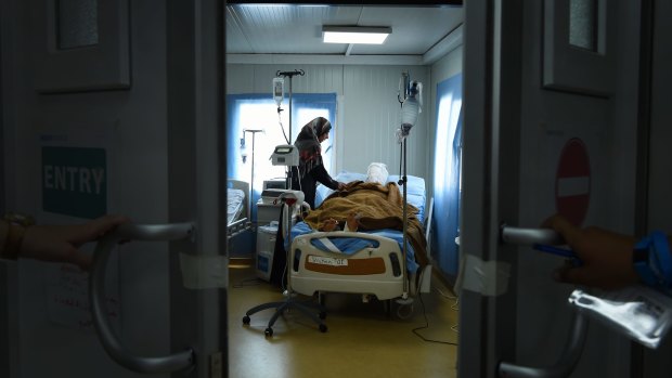 Sana Abdul Amir tends to her son, 18-year-old Abdulrahman Abdulaaly, at the Athba Field Hospital near Mosul, Iraq.