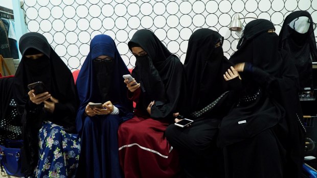 Women wearing niqabs chat at the home of a founder of the Niqab Squad in Bogor, Indonesia.